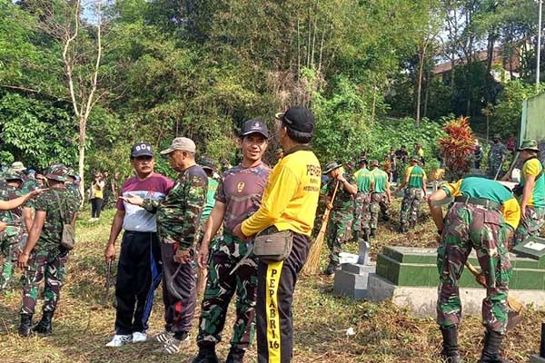 Personel TNI Gabungan karya bakti bersihkan TMP Veteran Mergosono. (ist) - Personel TNI Gabungan Karya Bakti Bersihkan TMP Veteran Mergosono