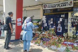 orang tengah berziarah di depan gate 13 stadion kanjuruhan