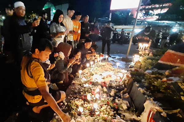 Pengunjung Alun-alun Batu memanjakan doa dan tabur bunga di depan pos Polisi Plaza Batu. (dik) - Pengunjung Alun-alun Batu Nyalakan Lilin dan Tabur Mawar Doakan Aremania