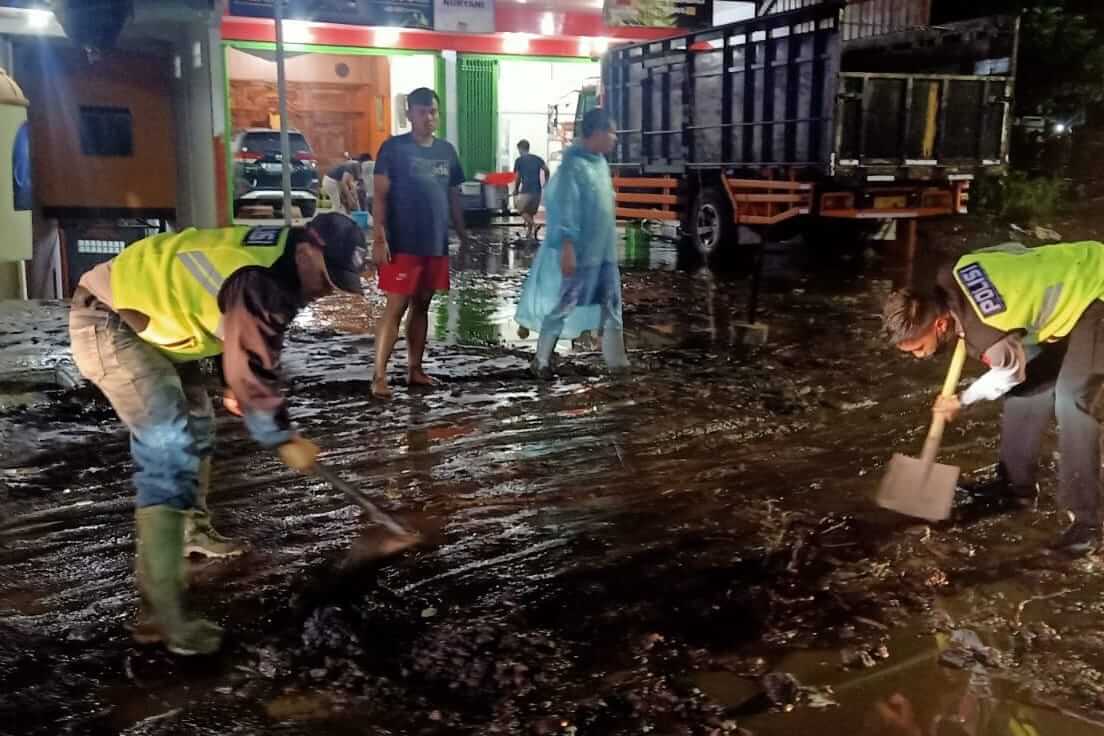 warga batu pindahkan lumpur usai banjir surut