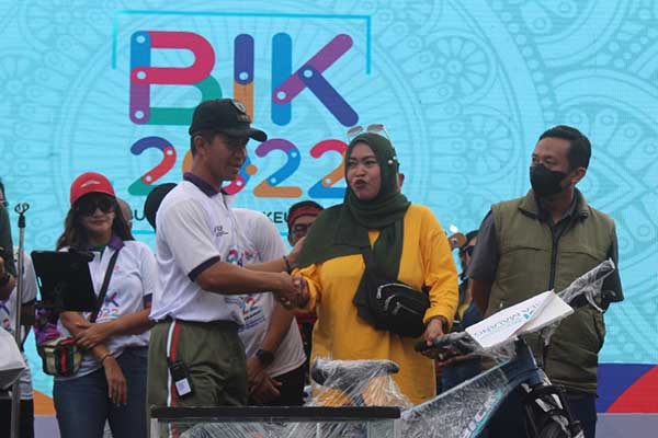 Dandim 0833 memberikan hadiah sepeda kepada salah satu peserta jalan sehat Bulan Inklusi Keuangan OJK. (ist) - Dandim 0833 Hadiri Puncak Acara Bulan Inklusi Keuangan 2022