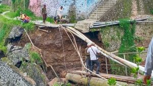 BAHAYA: Warga langsung melakukan penyambungan pipa yang sempat tertimpa longsoran plengsengan di Desa Punten, kemarin. (ist) - Longsor, Jembatan dan Pipa Hippam di Punten Bumiaji Putus