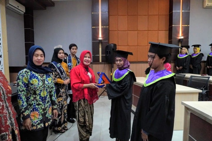 ketua tp pkk kota batu ny. wibi punjul santoso memberikan plakat kepada perwakilan wisudawan stoh.