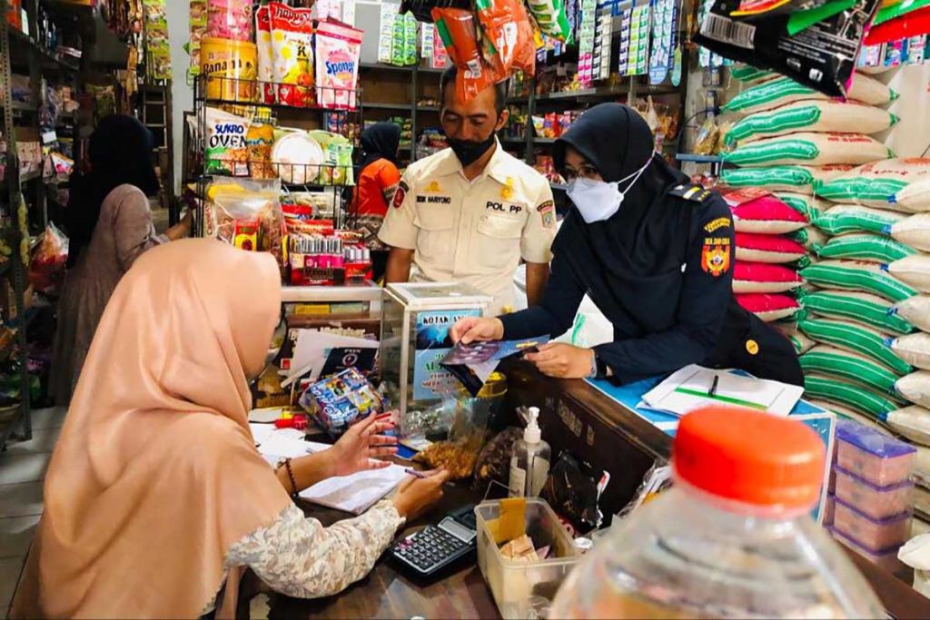 Memberikan penjelasan dan himbauan kepada pedagang agar tidak menerima rokok ilegal. (ws6) - Satpol PP Kabupaten Malang dan Bea Cukai Sobo Pasar Gempur Rokok Ilegal - Sobo Pasar Wonosari dan Kromengan