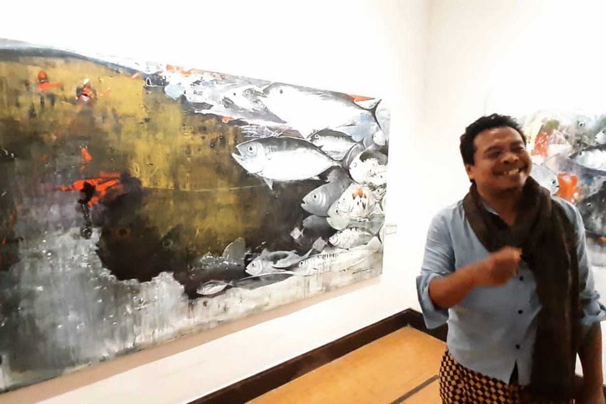 Pelukis Najib Amrullah, saat menceritakan salah satu hasil karyanya yang menguras emosi. (dik) - Pelukis Asal Tuban Sukses Gelar Pameran Tunggal di Galeri Raos Batu