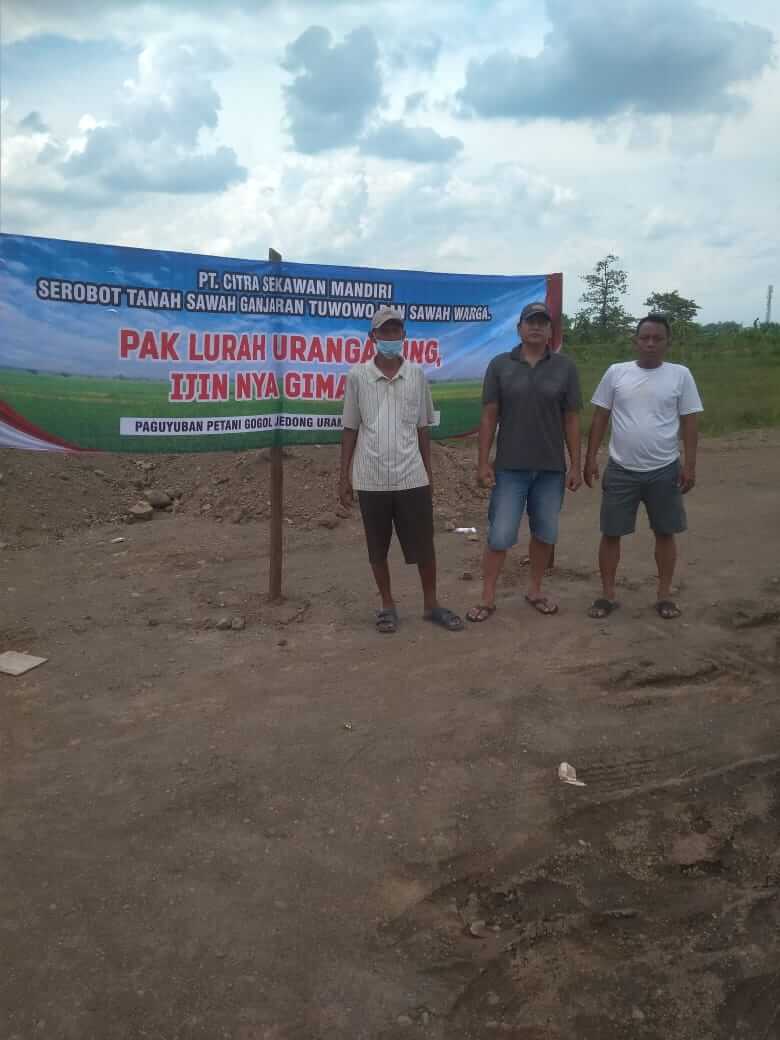 tiga warga dari 106 warga pemilik tanah gogol memasang spanduk di lahan yang diurug pengembang