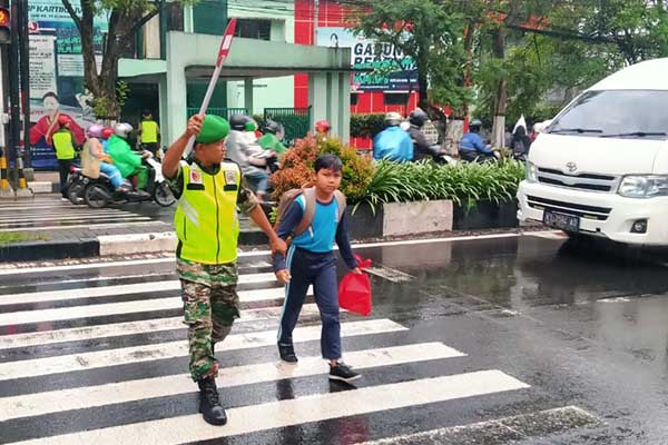 Babinsa bantu siswa SMP KARTIKA IV-8 menyeberang jalan. (ist) - Babinsa Bantu Siswa SMP KARTIKA IV-8 Menyeberang Jalan
