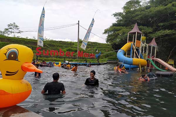 pengunjung menikmati wisata air di sumber maron malang