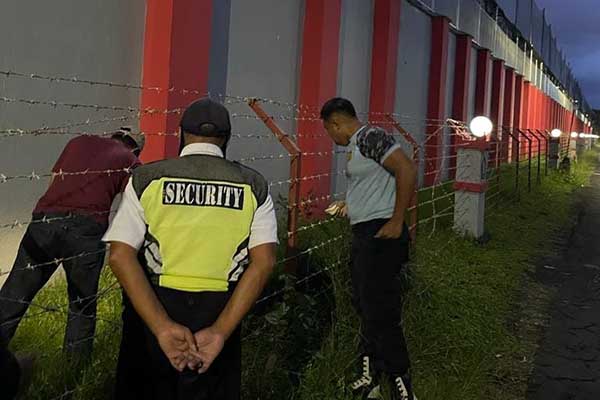 Petugas Lapas saat memeriksa kantong kresek misterius. (ist) - Penemuan Bungkusan Hitam di Luar Pagar Lapas Lowokwaru, Isinya Mengejutkan!