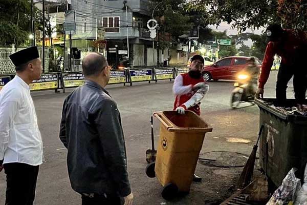 Pj Wali Kota Batu didampingi Kepala DLH berinteraksi dengan warga dan pasukan kuning. (ist) - Pj Walikota Batu Serap Aspirasi Petugas Kebersihan di Alun-alun