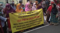 puluhan korban membentangkan spanduk sebelum sidang di pn sidoarjo11