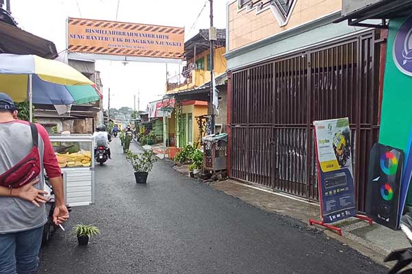 Sejumlah pot tanaman yang dipasang di tengah jalan aspal baru menuju Jembatan Pelor. (ws7) - Ingatkan Pengendara Ngebut, Warga Jembatan Pelor Pasang Pot dan Spanduk