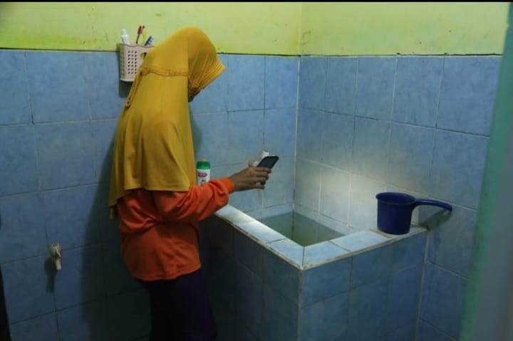 warga saat mengecek jentik nyamuk di kamar mandi