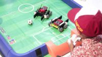 Dua robot berebut bola di arena mini. (ws7) - Kenalkan Robotika pada Anak Usia Dini Melalui Lomba Sepak Bola Robotik