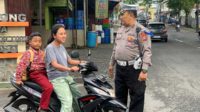 Petugas menegur salah seorang pengendara R2 yang tidak mengamankan dirinya dengan helm saat mengantar sekolah. (ist) - Satlantas Polres Batu Beri Teguran Simpatik pada Pelanggar Lalin