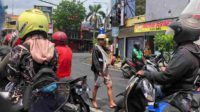 salah satu pengamen yang tengah menggendong anaknya saat mengamen di pertigaan kepanjen