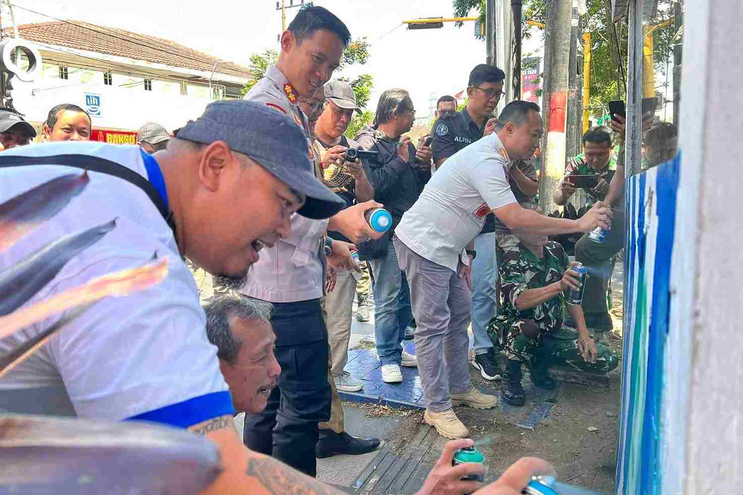 kapolres didampingi sekpol pp dan perwakilan aremania memulai lomba mural dengan semprotan cat pertama kali