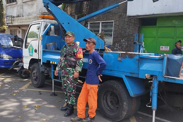 Babinsa Klojen dampingi perampingan pohon di Jalan Patimura. (ist) - Babinsa Klojen Dampingi Perampingan Pohon di Jalan Patimura