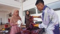 Fikrah menuangkan natol ke kain yang sudah diikat. (jup) - Sulap Baju Bekas Jadi Baju Menarik dengan Teknik Ikat Celup