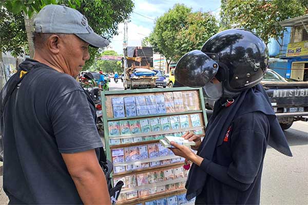 Martono saat melayani penukaran uang. (ist) - Jasa Penukaran Uang Sudah Menjamur di Awal Bulan Puasa
