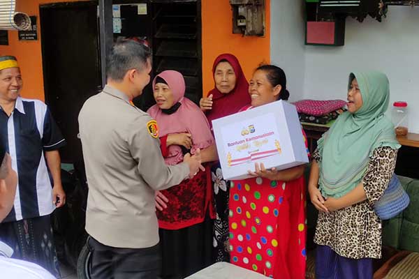 Senyum bahagia warga saat menerima bingkisan dari Kapolresta Malang Kota. (rhd) - Kapolresta Makota Bagikan Bantuan pada Warga Bantaran Rel KA