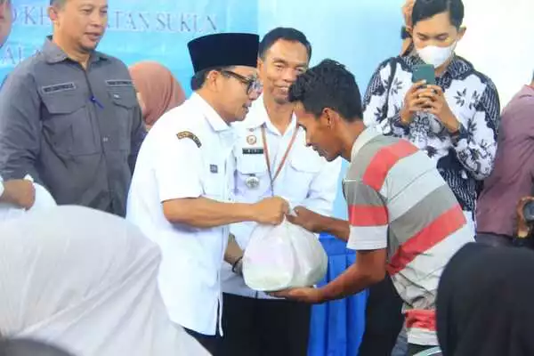 sutiaji menyerahkan sembako dari bkm wargomulyo kepada masyarakat ciptomulyo. (jup) - Walikota Malang Apresiasi BKM Wargomulyo Bagi-bagi Sembako ke Ratusan Warga