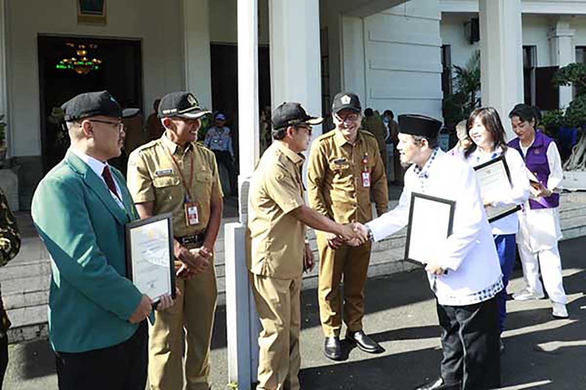 Wali Kota Malang menyerahkan penghargaan kepada sejumlah relawan dan nakes. (ws7) - Kota Malang Sukses Tingkatkan Derajat Kesehatan Mandiri, Tangguh, Berkelanjutan