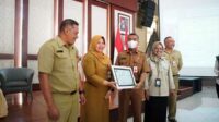 Kadisnaker dan Kepala BPJS Ketenagakerjaan Batu Kota, serahkan penghargaan untuk Bendahara OPD dan Desa terbaik. (ist) - Bendahara OPD dan Desa Terbaik Diganjar Penghargaan BPJS Ketenagakerjaan