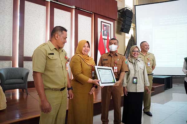 Kadisnaker dan Kepala BPJS Ketenagakerjaan Batu Kota, serahkan penghargaan untuk Bendahara OPD dan Desa terbaik. (ist) - Bendahara OPD dan Desa Terbaik Diganjar Penghargaan BPJS Ketenagakerjaan
