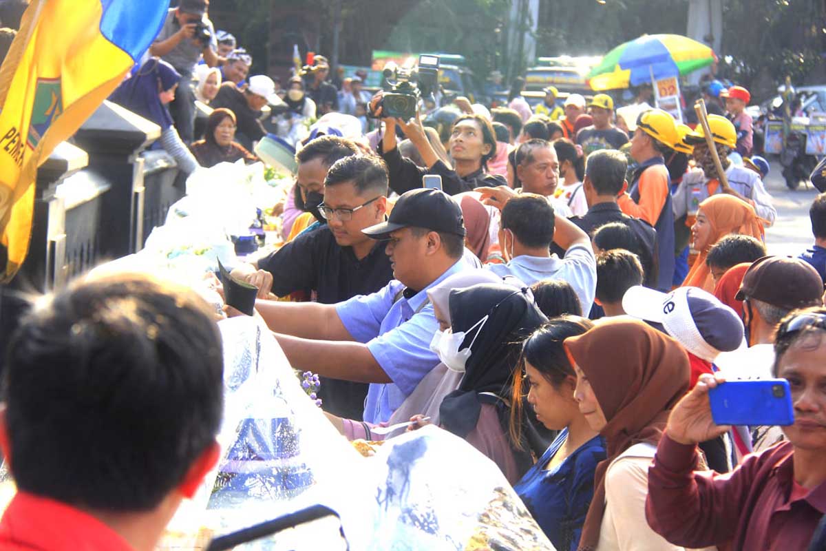 Masyarakat berebut makanan dari tumpeng yang dibagikan. (jup) - Warnai HUT 109 Kota Malang, Pemkot Malang Kirab Ribuan Tumpeng
