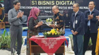 Penyerahan potongan tumpeng simbolis launching prodi S1 Digital Bisnis FEB UWG. (rhd) - Universitas Widyagama Launching Prodi S1 Bisnis Digital