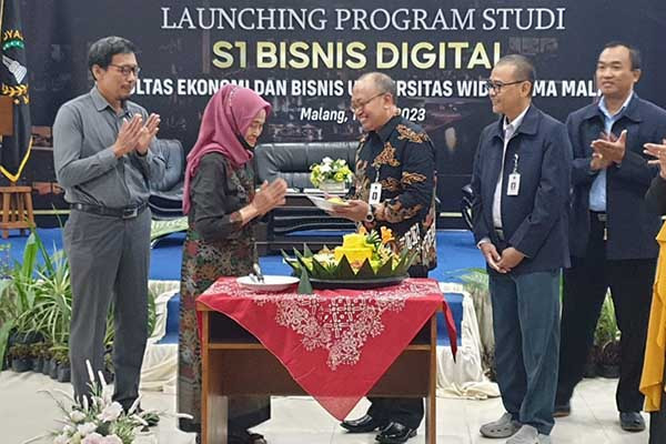 Penyerahan potongan tumpeng simbolis launching prodi S1 Digital Bisnis FEB UWG. (rhd) - Universitas Widyagama Launching Prodi S1 Bisnis Digital