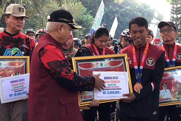 Penyerahan uang tunai kepada para atlet sebagai bentuk apresiasi Pemerintah Kabupaten Malang. (wul) - Pemkab Malang Berikan Apresiasi Bagi Enam Atlet Peraih Medali Sea Games Kamboja