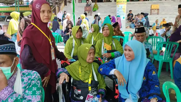 Ruhay, cucu jamaah haji lansia menangis saat mendampingi Satiwe Ritmo Latifa (85). (udi) - Jamaah Haji Lansia Asal Pamekasan Menangis Karena Tidak Ada Pendamping dari Keluarga