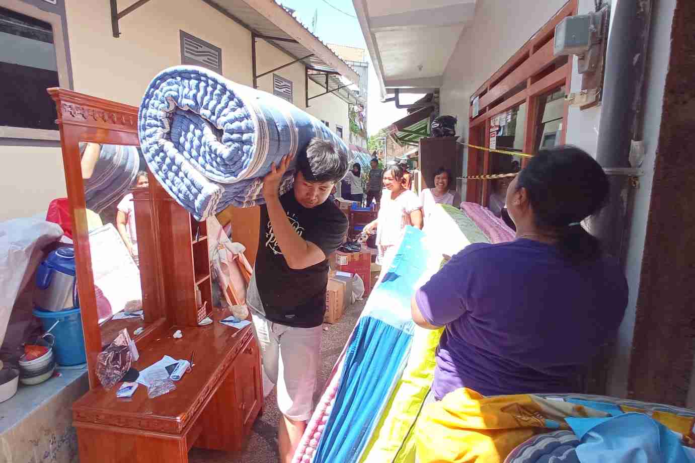 warga mengeluarkan barang barang khawatir longsor susulan