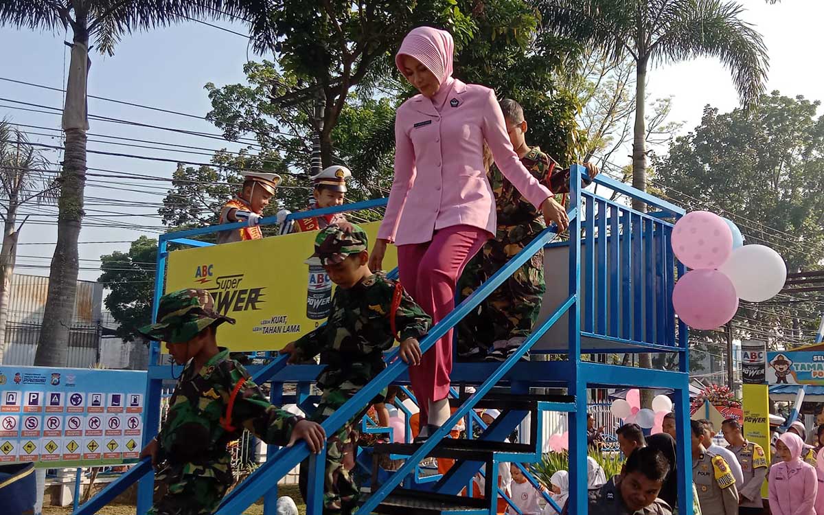 MINIATUR: Ketua Bhayangkari Cabang Malang, Ny Ujik Putu Kholis, bersama siswa-siswi usia dini mencoba miniatur jembatan penyeberangan. (ist) - Kado HUT ke-77, Polres Malang Resmikan Taman Lalu Lintas Budhi Luhur Bhayangkara