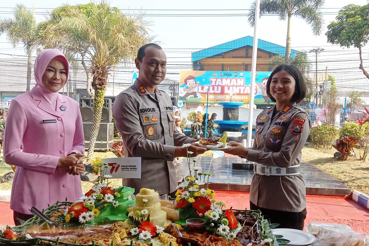 TUMPENG: Pemotongan tumpeng oleh Kapolres Malang, AKBP Kholis, yang diberikan kepada Kasat Lantas AKP Agnis. (ist) - Kado HUT ke-77, Polres Malang Resmikan Taman Lalu Lintas Budhi Luhur Bhayangkara
