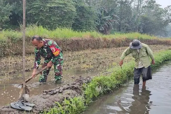 Babinsa Kedungkandang bersama masyarakat Wonokoyo siapkan lahan pertanian. (ist) - Wujudkan Ketahanan Pangan, Babinsa Kedungkandang Bersama Masyarakat Wonokoyo Siapkan Lahan Pertanian