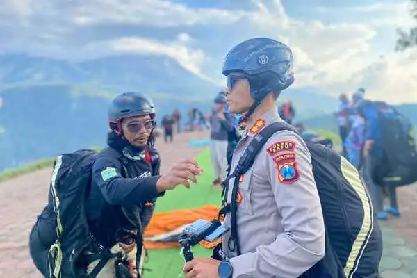 Kapolres Batu, AKBP Oskar Syamsuddin SIK MT saat akan melakukan take off paralayang dari area take off Gunung Banyak. (ist) - Kapolres Batu Jajal Paralayang di Penutupan Batu International Paragliding Festival 2023