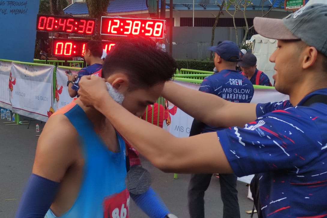 Pelari rute 5K mencapai garis finish pertama dalam waktu 12.38 menit dan dikalungi medali finisher. (rhd)