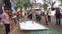 Proses pembongkaran reklame bertema politik oleh Satpol PP Kota Malang. (SERU.co.id/jup) - Satpol PP Kota Malang Bongkar Puluhan Reklame Bertema Politik