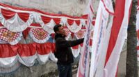 Topan dengan dagangannya di Jalan Hasanuddin, Pesanggrahan, Kota Batu. (Seru.co.id/dik) - Pedagang Bendera dan Umbul-umbul Agustusan Mulai "Serbu" Jalanan