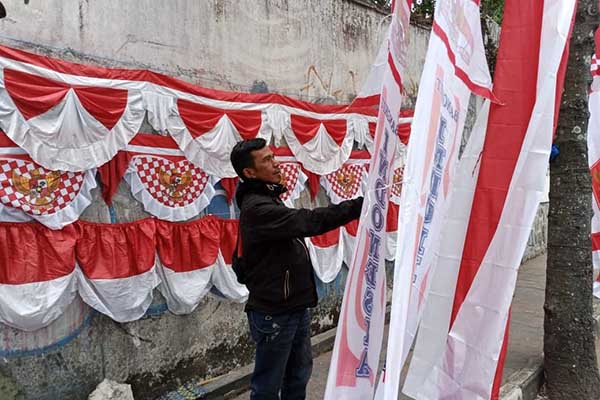 Topan dengan dagangannya di Jalan Hasanuddin, Pesanggrahan, Kota Batu. (Seru.co.id/dik) - Pedagang Bendera dan Umbul-umbul Agustusan Mulai "Serbu" Jalanan