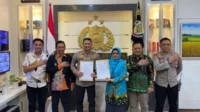 Kapolresta Malang Kota, Kombes Pol Budi Hermanto dan Ketua KPU kota Malang, Aminah Asminingtyas, menunjukkan berkas Mou yang telah ditandatangani.(ist) - Sukseskan Pemilu 2024, Polresta Makota dan KPU Kota Malang Tandatangani MoU