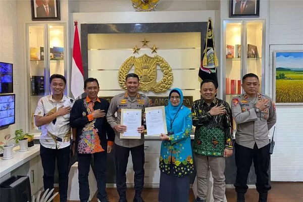 Kapolresta Malang Kota, Kombes Pol Budi Hermanto dan Ketua KPU kota Malang, Aminah Asminingtyas, menunjukkan berkas Mou yang telah ditandatangani.(ist) - Sukseskan Pemilu 2024, Polresta Makota dan KPU Kota Malang Tandatangani MoU