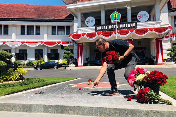 Proses aksi Performance ART oleh Mukmin Ahmad atau Soge, di depan Halaman Balai Kota Malang. (Seru.co.id/wul) - Tolak Konvoi HUT Arema, Seniman Soge Rawat Ingatan Tragedi Kanjuruhan dengan Performance Art