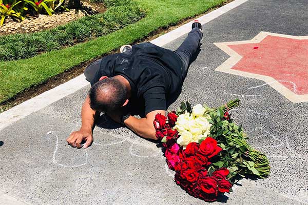 Proses aksi Performance ART oleh Mukmin Ahmad atau Soge, di depan Halaman Balai Kota Malang. (Seru.co.id/wul) - Tolak Konvoi HUT Arema, Seniman Soge Rawat Ingatan Tragedi Kanjuruhan dengan Performance Art