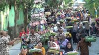 Warga Dungus menggelar arak-arakan gunungan dan encek berupa makanan dan hasil bumi sebagai bagian dari acara bersih desa atau nyadran - Pertahankan Adat, Warga Dungus Ngawi Gelar Tradisi Nyadran