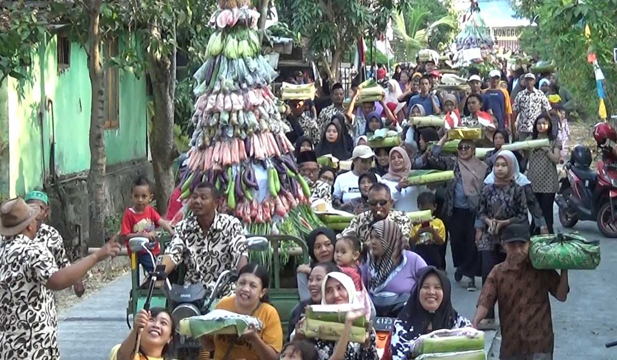 Warga Dungus menggelar arak-arakan gunungan dan encek berupa makanan dan hasil bumi sebagai bagian dari acara bersih desa atau nyadran - Pertahankan Adat, Warga Dungus Ngawi Gelar Tradisi Nyadran