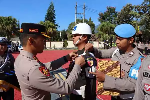 Kapolres Batu memasangkan pita tugas pada Personel yang terlibat Ops Zebra Semeru 2023. (ist) - Kapolres Batu Pimpin Apel Gelar Pasukan Ops Zebra Semeru 2023